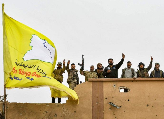 Forze Democratiche Siriane issano la bandiera a Baghouz Forze Democratiche Siriane issano la bandiera a Baghouz