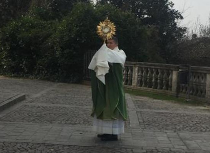 Don Gabriele Bernardelli benedice i fedeli dal sagrato dopo la messa Don Gabriele Bernardelli benedice i fedeli dal sagrato dopo la messa