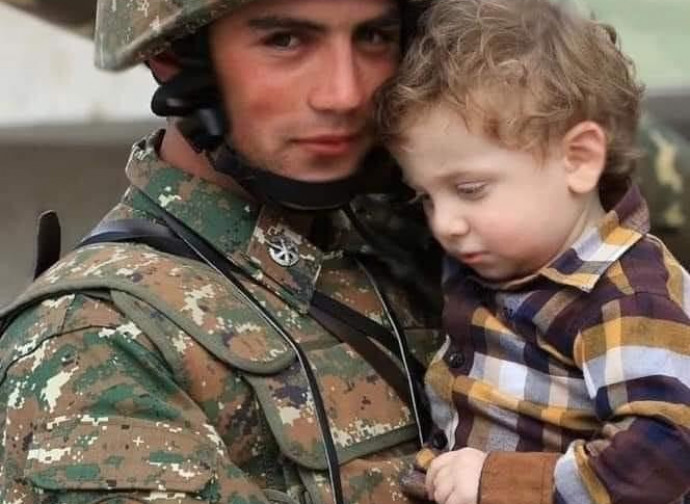 Giovane soldato protegge un bimbo