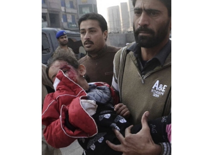 Un padre con il figlio ferito dai talebani nell'assalto alla scuola di Peshawar Un padre con il figlio ferito dai talebani nell'assalto alla scuola di Peshawar