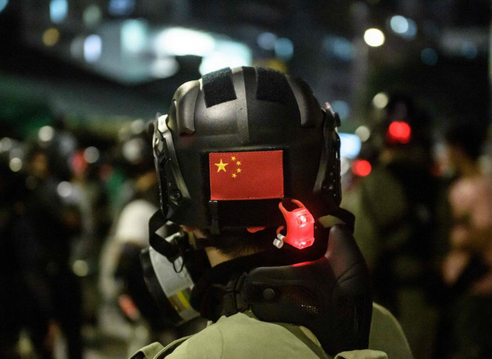 Poliziotto anti-sommossa con insegne cinesi a Hong Kong Poliziotto anti-sommossa con insegne cinesi a Hong Kong